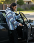 Person getting into a car wearing a patterned sweater