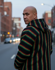 Man wearing a rasta striped hoodie on a city street
