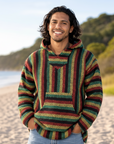 Man wearing a colorful striped hoodie on a beach