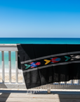 black fish blanket hung over a rustic beach bach railing