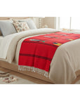 Bed with a red runner and white bedding in a bedroom setting