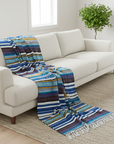 White sofa with a colorful striped blanket in a bright living room.
