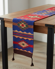 Woven table runner with geometric patterns on a wooden table.