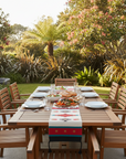 Outdoor dining setup with a wooden table and chairs in a garden setting.