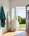 Traditional mexican fish design blanket hung up by the front door of a bungalow with a surfboard in the corner