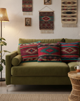 Three cushions on olive velvet sofa, boho setting