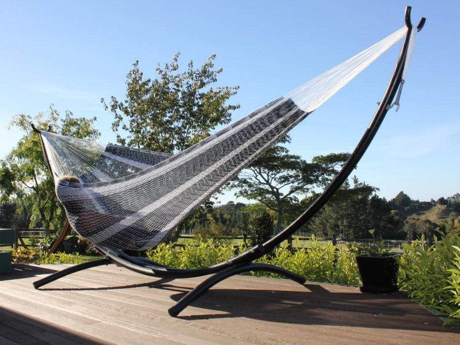 Black and white hammock in metal arc hammock stand