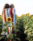 Mum and child in sunflower field with Mexican blanket