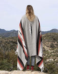 Women wrapped in Mexican blanket overlooking desert