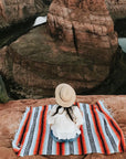 Woman on Mexican picnic rug overlooking river