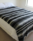 Black and white Mexican blanket on bed