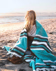 Women wrapped in Mexican blanket on beach