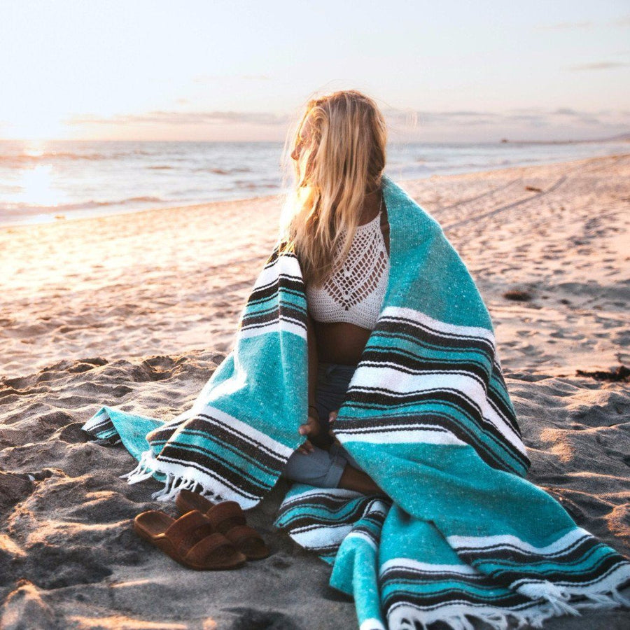 Women wrapped in Mexican blanket on beach