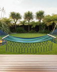 Blue hammock hanging between wooden posts in a garden setting