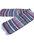 A Mexican falsa blanket with pink and grey stripes, featuring intricate patterns and artisanal craftsmanship.