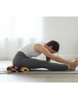 woman stretching in yoga pose with Mexican blanket under thighs
