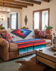 Living room with a brown sofa, colorful blanket, and wooden coffee table.