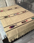Beige blanket with fish patterns on a bed in a bedroom setting