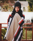 Woman wrapping up in beige coloured Mexican blanket