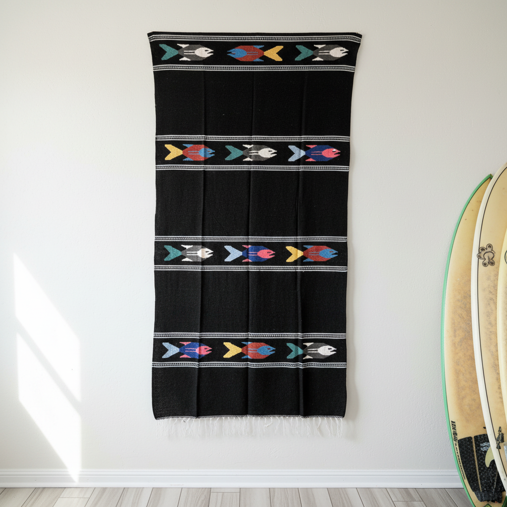 Black towel with colorful patterns hanging on a white wall