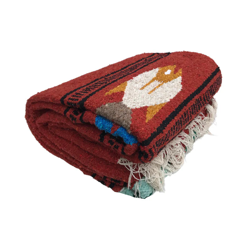 Folded red blanket with a colorful fox design on a white background
