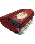 Folded red blanket with a colorful fox design on a white background