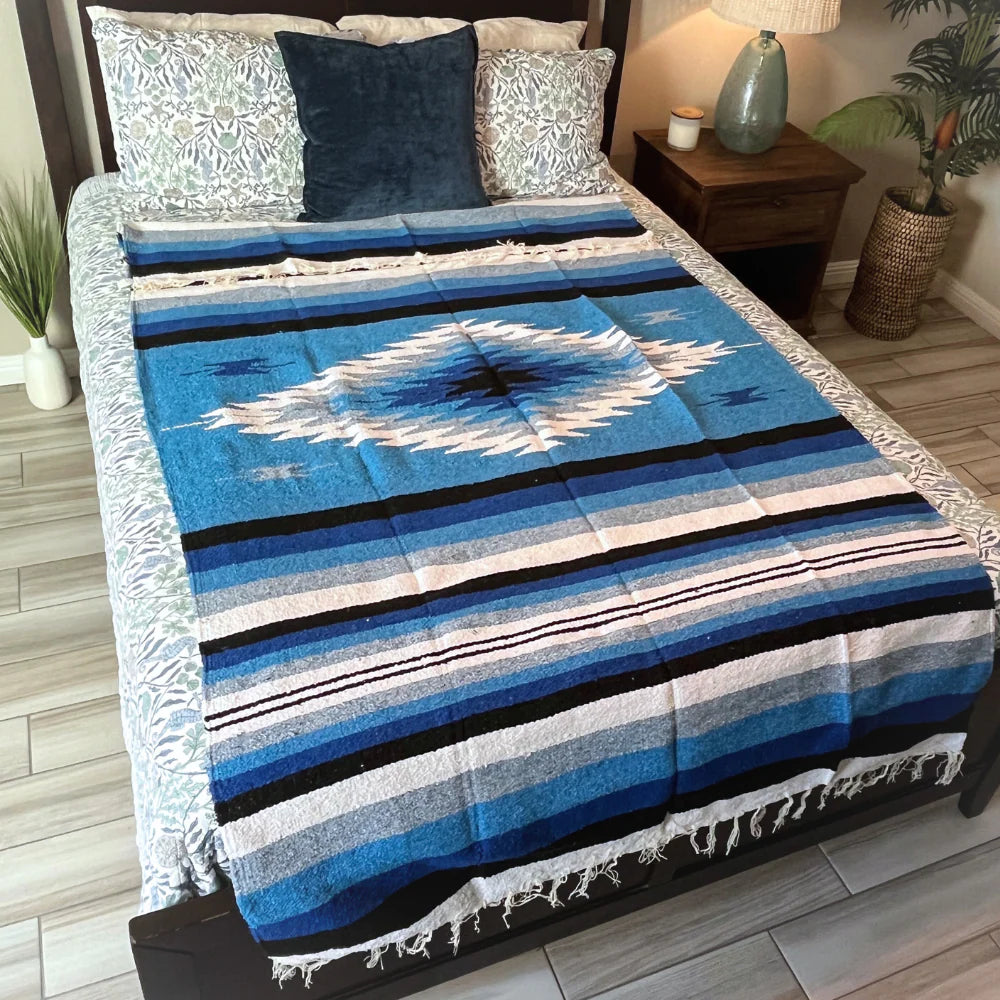 Blue striped blanket on a bed with pillows in a bedroom setting