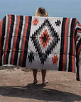 Woman spreading blanket out near beach