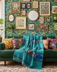 Teal fish blanket in green living room with lots of pictures on the wall