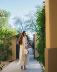 woman walking with leather blanket carrying straps