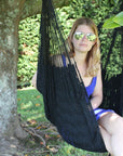 Black chair hammock hanging from tree