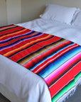 Red Mexican throw on bed