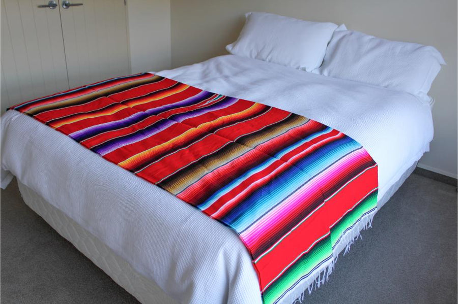 Red Mexican throw on bed