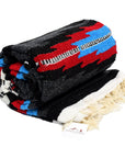 Rolled up saltillo Mexican blanket in dark colours