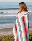 Woman wrapped in Mexican falsa blanket at beach