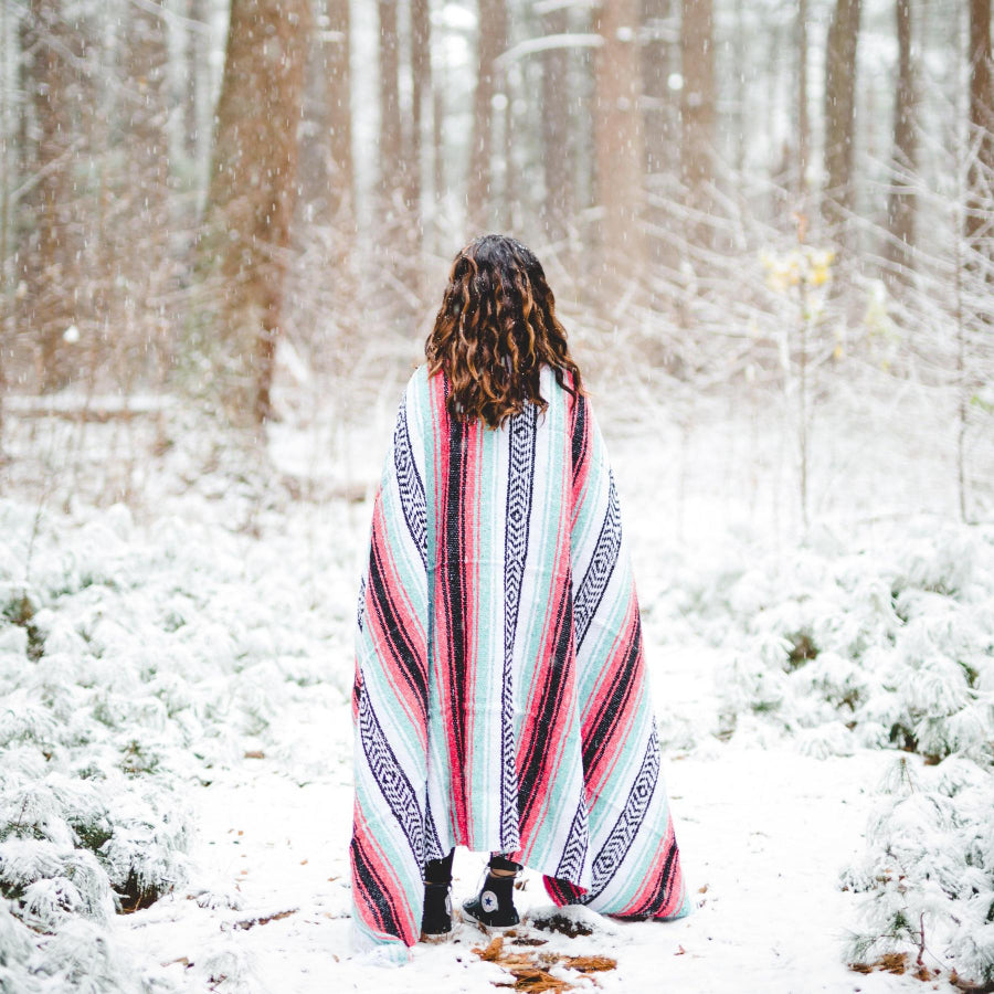 Woman in snow wrapped in Mexican blanket