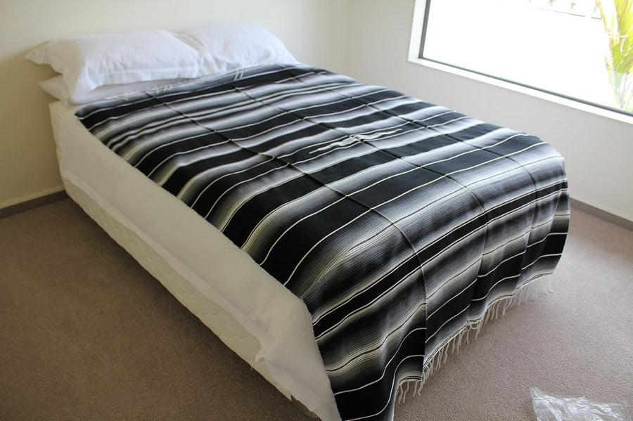 Black and white Mexican blanket on bed