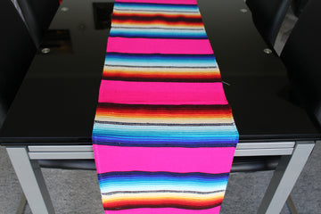 Pink striped table runner in Mexican style on glass table