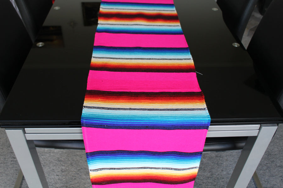 Pink striped table runner in Mexican style on glass table